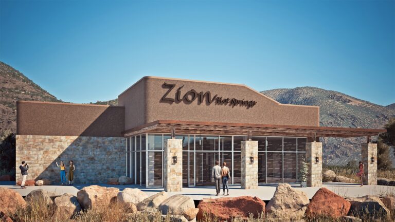 Exterior of the Zion Hot Springs bar, with people in swimsuits enjoying drinks under a wooden pergola in a desert mountain setting.